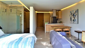 A modern hotel room with a bed, a sofa, a kitchenette, and a dining area. - Intimate & Bright Studio w/ Rooftop Pool in the Art District San Jose Del Cabo (San José del Cabo)