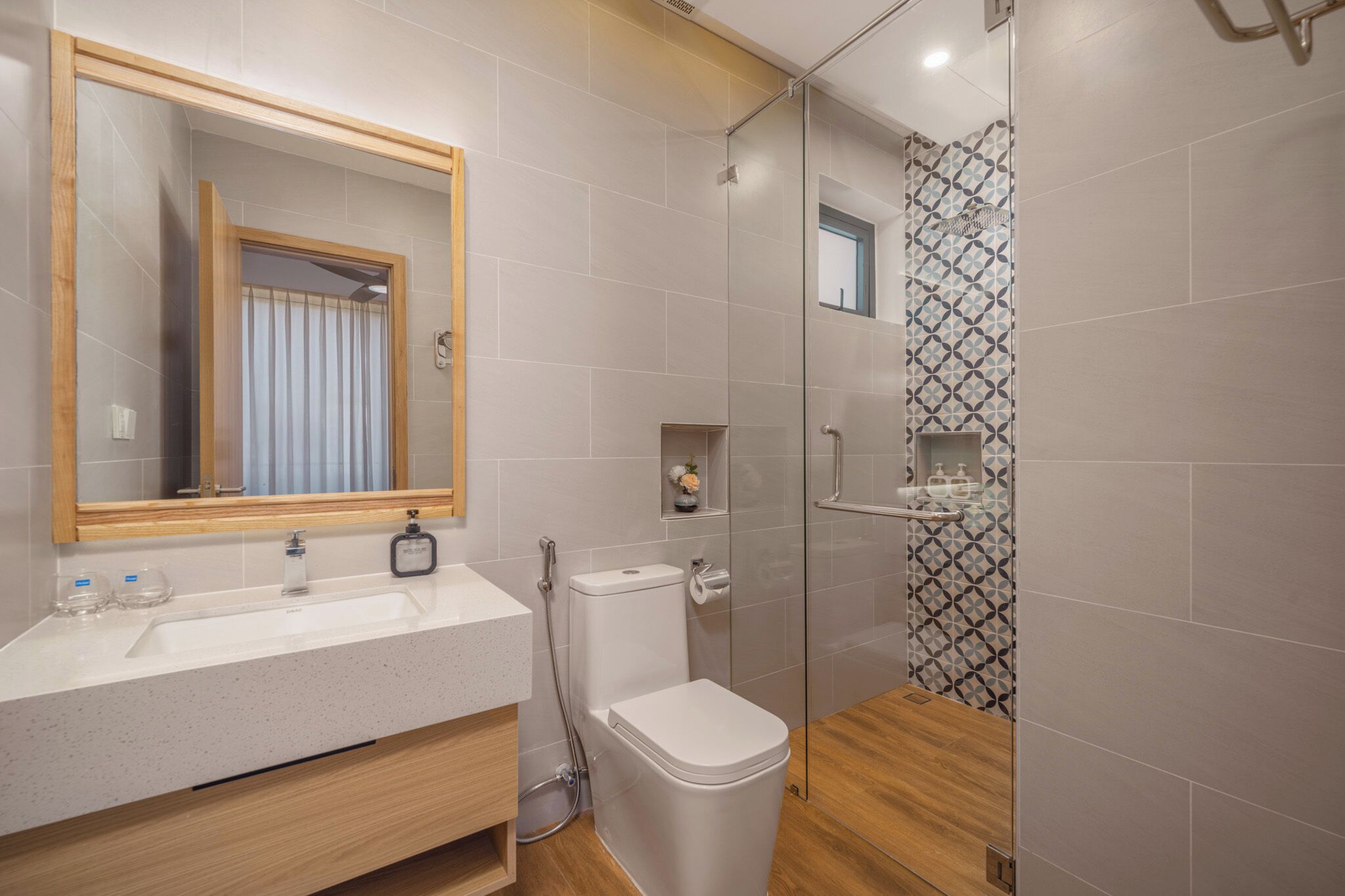 Ein modernes Badezimmer mit einer Duschkabine aus Glas, einem weißen Waschbecken und einer Toilette.