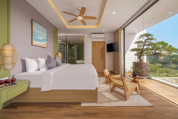 A modern bedroom with a large bed, a ceiling fan, a TV, and a view of the outdoors. - Amazing Newly Built Pool Villas Danang (Da Nang)