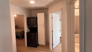Una habitación con kitchenette, cama y baño.