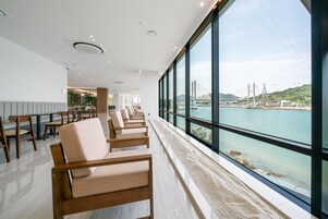 Un moderno vestíbulo de hotel con vista a un puente y al agua.