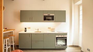 A compact kitchen with a built-in oven, a sink, and a countertop.