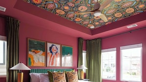A bedroom with a large bed, green curtains, and a ceiling with a colorful pattern. - Lyric | Luxury Stay with Rooftop & Firepit (Nashville)