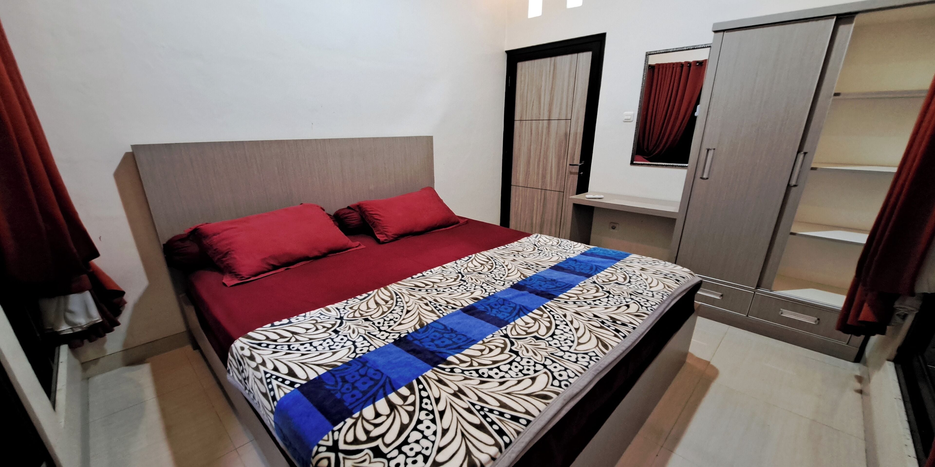 Un dormitorio con cama, armario y una mesita.