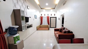 A modern living room with a sofa, a TV, and a water dispenser. - Villa Zam Zam Puncak (Cisarua)