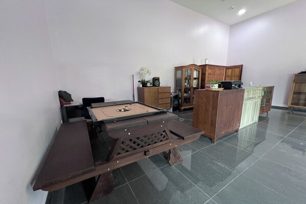 A billiards table with a pool cue and balls, a wooden cabinet, and a glass display case in a room with tiled flooring. - Jasa Resort Sungai Lembing (Sungai Lembing)