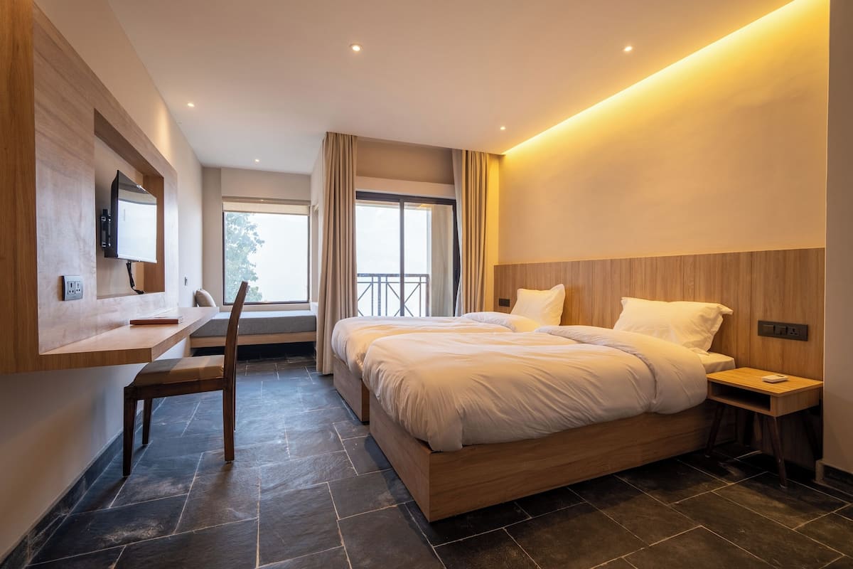 A modern bedroom with a large bed, a desk, and a chair.