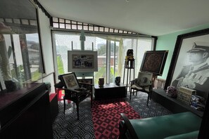 A room with a large window, a black and white patterned floor, a red and black rug, and a green sofa. - 64 Sweet Home Dusit Bkk (Bangkok)