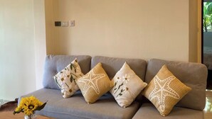A modern living room with a grey sectional sofa, a wooden coffee table, and decorative pillows. - Jaokhun Panorama Villas, Patong (Patong)
