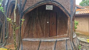 A treehouse with a wooden door and a small sign above it. - Tontarn Resort And Spa (Khanom)
