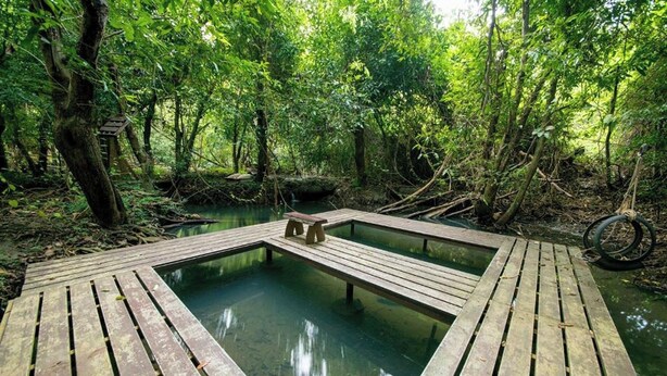 A rectangular wooden deck with a central pool surrounded by dense forest. - Tontarn Resort And Spa (Khanom)