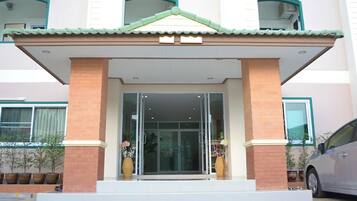 A building with a tiled roof, a glass entrance, and a brick facade.