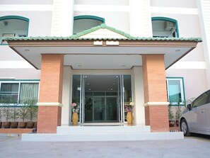 A building with a tiled roof, a glass entrance, and a brick facade. - Udon Perfect Mansion (Udon Thani)
