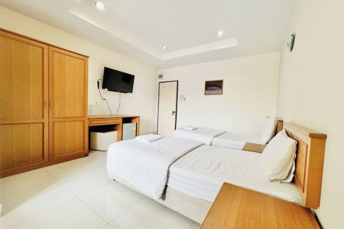A hotel room with a large bed, a desk, and a TV.
