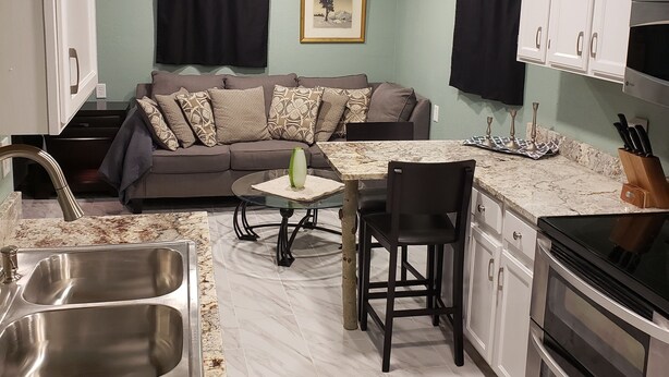 A compact kitchen with a dining area, a built-in oven, and a sink. - Mountain Chic Cabin Retreat (Woodland Park)
