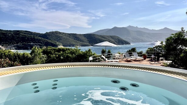 Ein Whirlpool mit Blick auf eine gebirgige Küstenlandschaft.