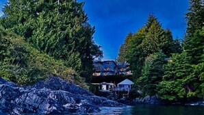 A coastal property with a house surrounded by dense forest. - Tofino Oceanfront Hotel Suite (Tofino)