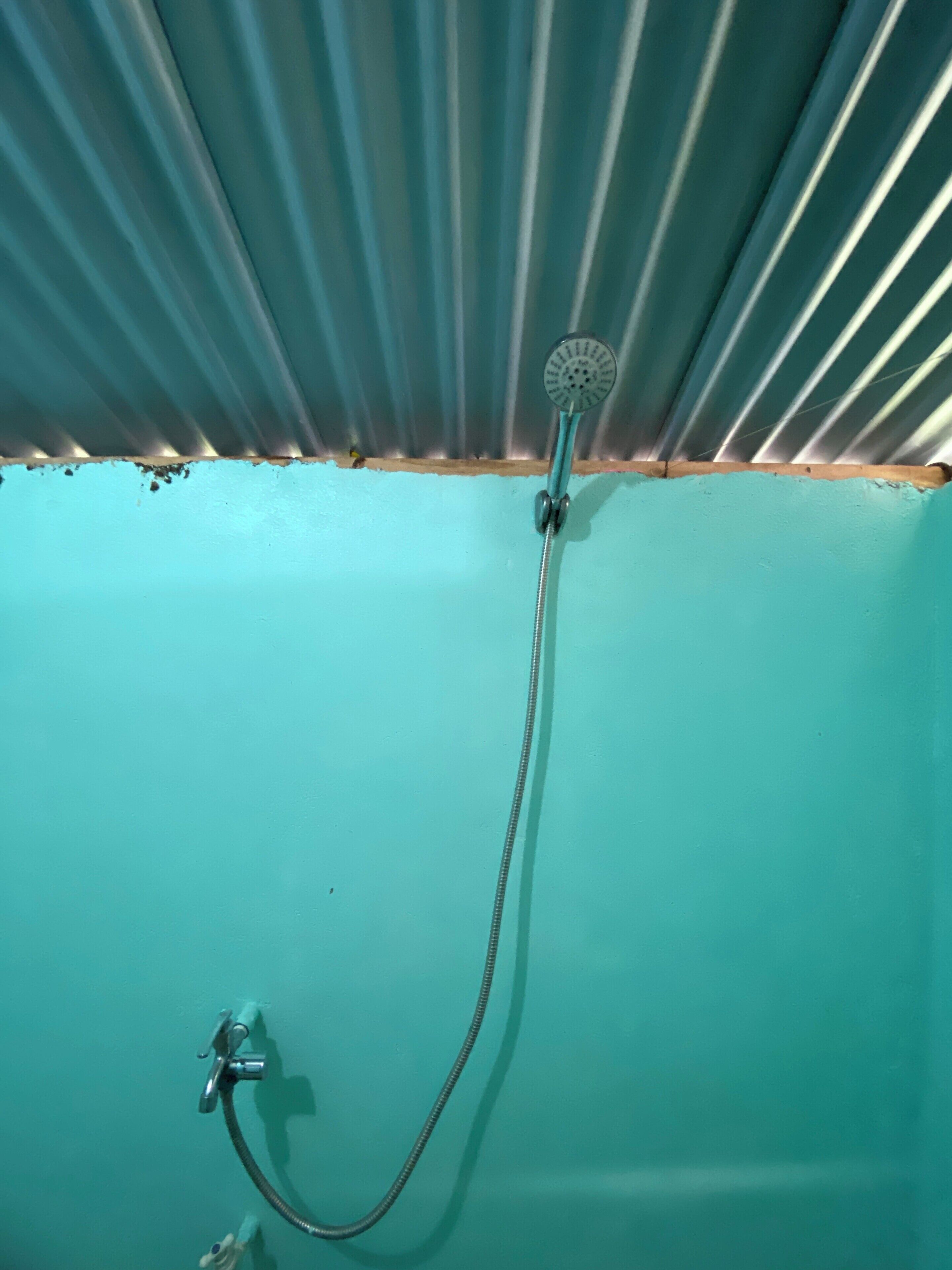 A shower with a handheld showerhead and a handheld faucet.