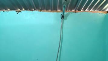 A shower with a handheld showerhead and a handheld faucet.