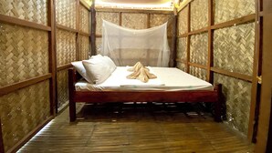 A room with a bed, mosquito net, and woven bamboo walls. - Ocam Ocam Casadyan Inn (Busuanga)