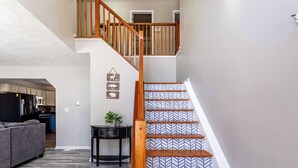 A staircase with patterned steps and a wooden railing, leading to an upper floor. - Lake Front | 5 Bedroom | Fire Pit | Pet Friendly (Tobyhanna)