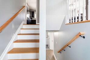 Eine Treppe mit Holzbodenstufen und weißen Wänden.