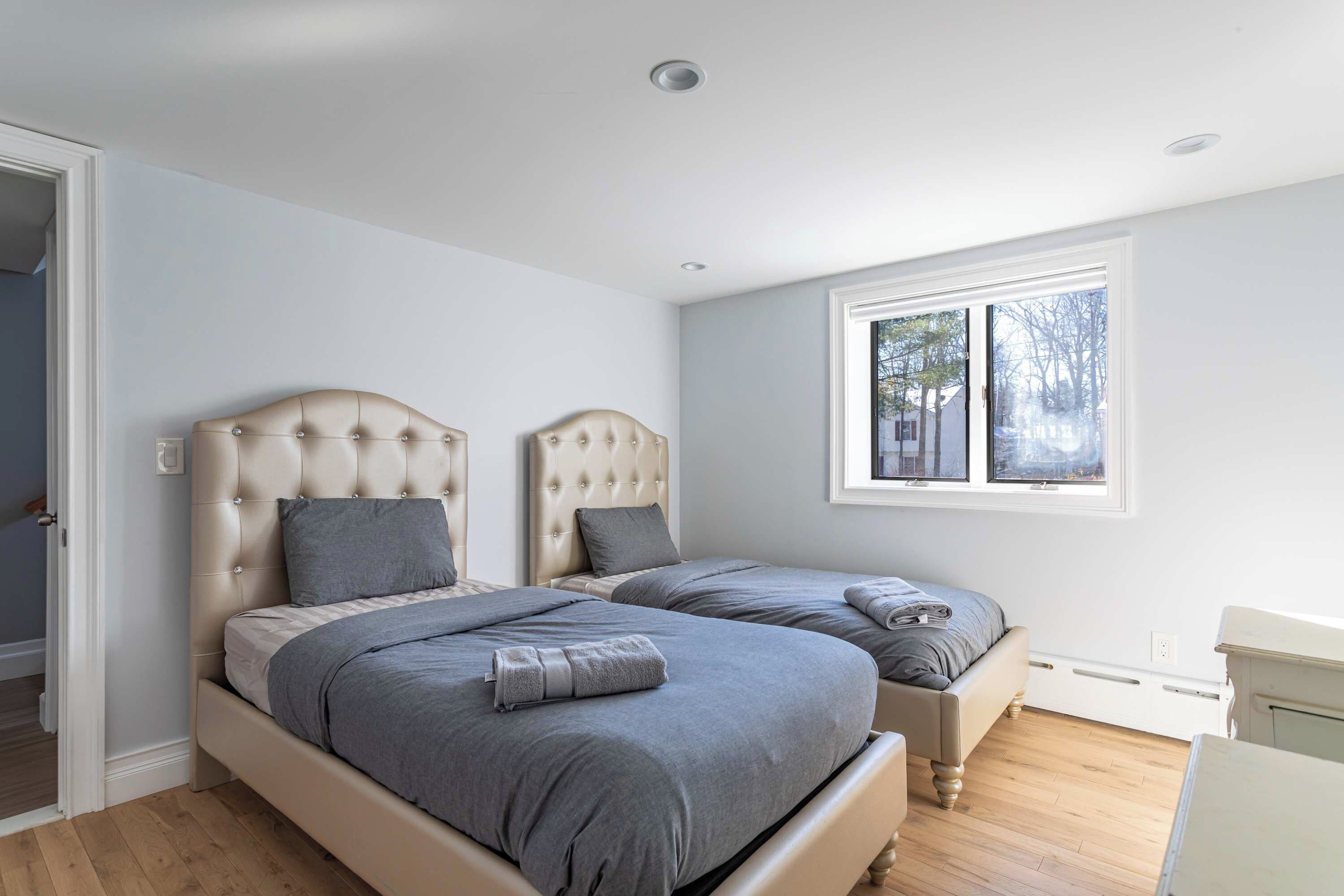 Een slaapkamer met twee bedden, een raam en een deur.