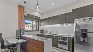 A modern kitchen with a built-in oven, microwave, and refrigerator.