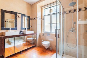 Une salle de bain moderne avec une douche à parois de verre, un grand miroir et un meuble-lavabo en bois.