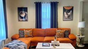 A living room with a sectional sofa, a coffee table, and a rug.