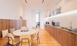 Cuina moderna amb taula rodona, armaris de fusta i forn encastrat.