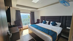 Una camera da letto con un letto, una sedia, una scrivania e vista sull'esterno.
