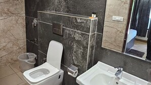 Un bagno con il water, un lavandino e uno specchio.