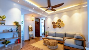 Een moderne woonkamer met een bank, een houten salontafel en decoratieve wanddecoratie.
