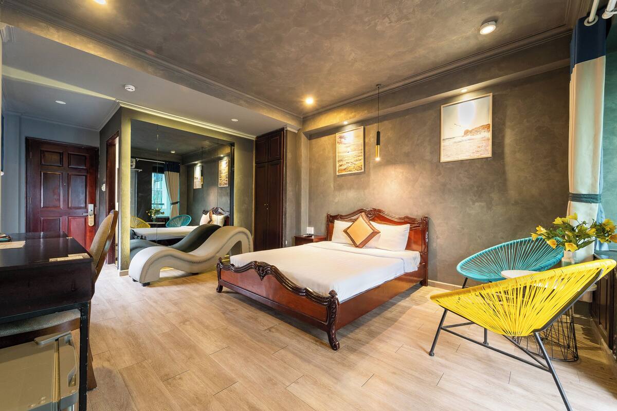 A bedroom with a wooden bed, a yellow chair, and a view of the hallway.