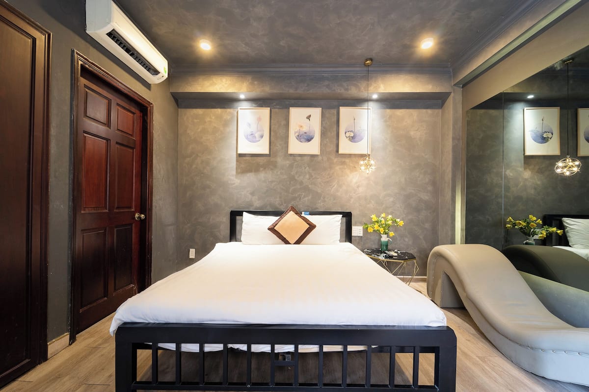 A bedroom with a bed, bedside table, and a chair.