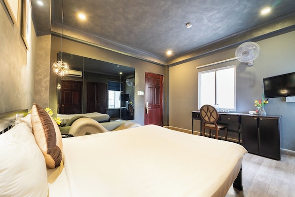 Une chambre à coucher comprenant un lit, une table de chevet et un bureau avec une chaise.