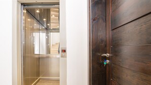 Un ascenseur avec un intérieur métallique et une porte en bois.