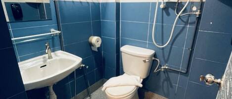 A bathroom with a white sink, toilet, and shower.