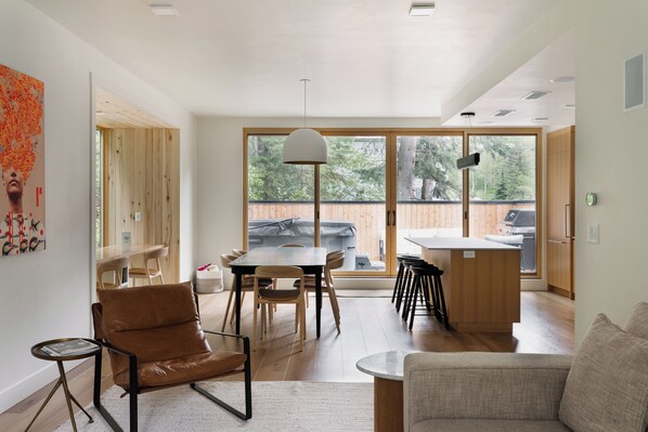 Un intérieur moderne comprenant un coin repas, un canapé et une cuisine.