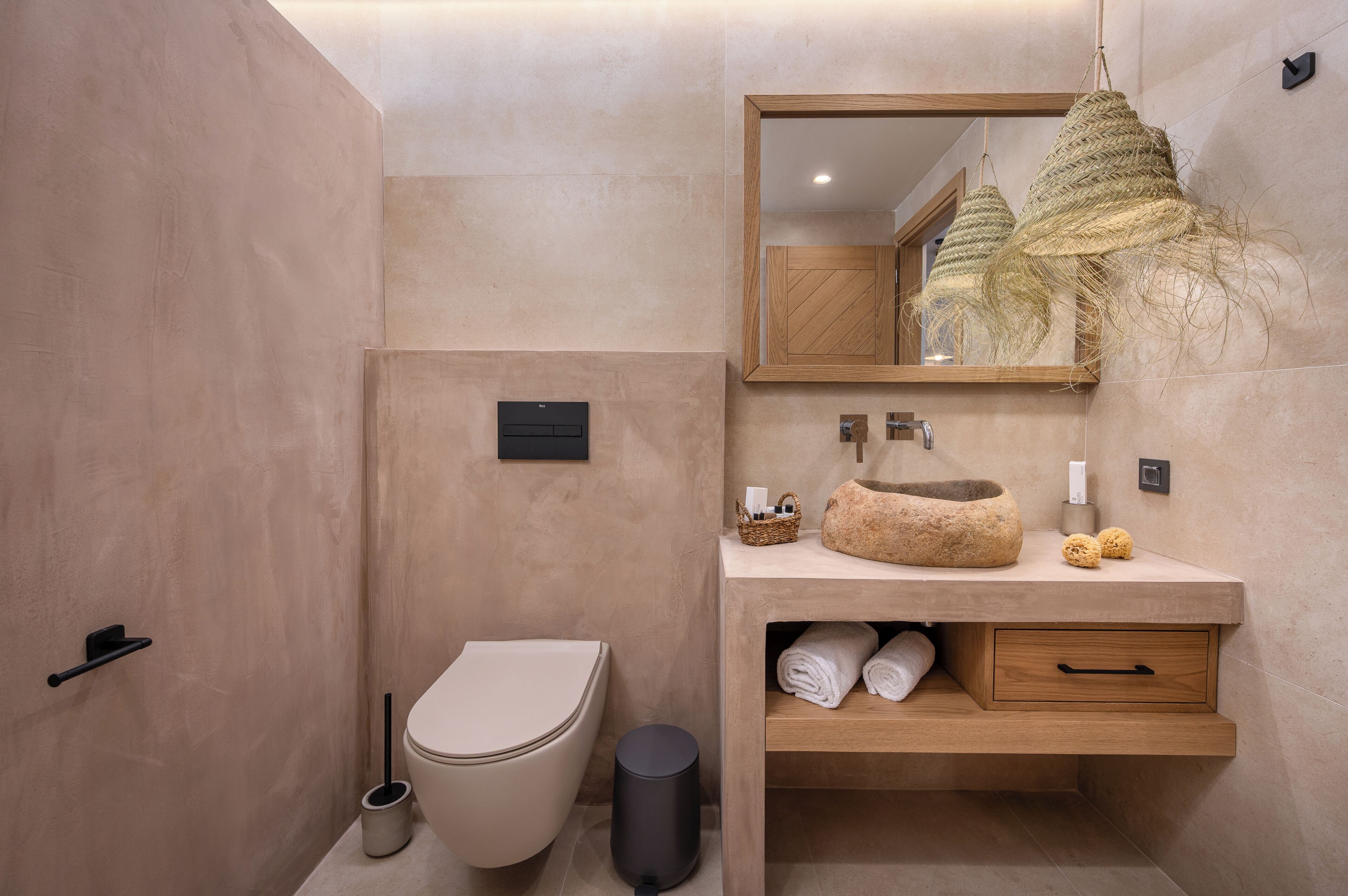 Une salle de bain moderne équipée de toilettes, d’un lavabo, d’un miroir et d’un espace pour ranger les serviettes.