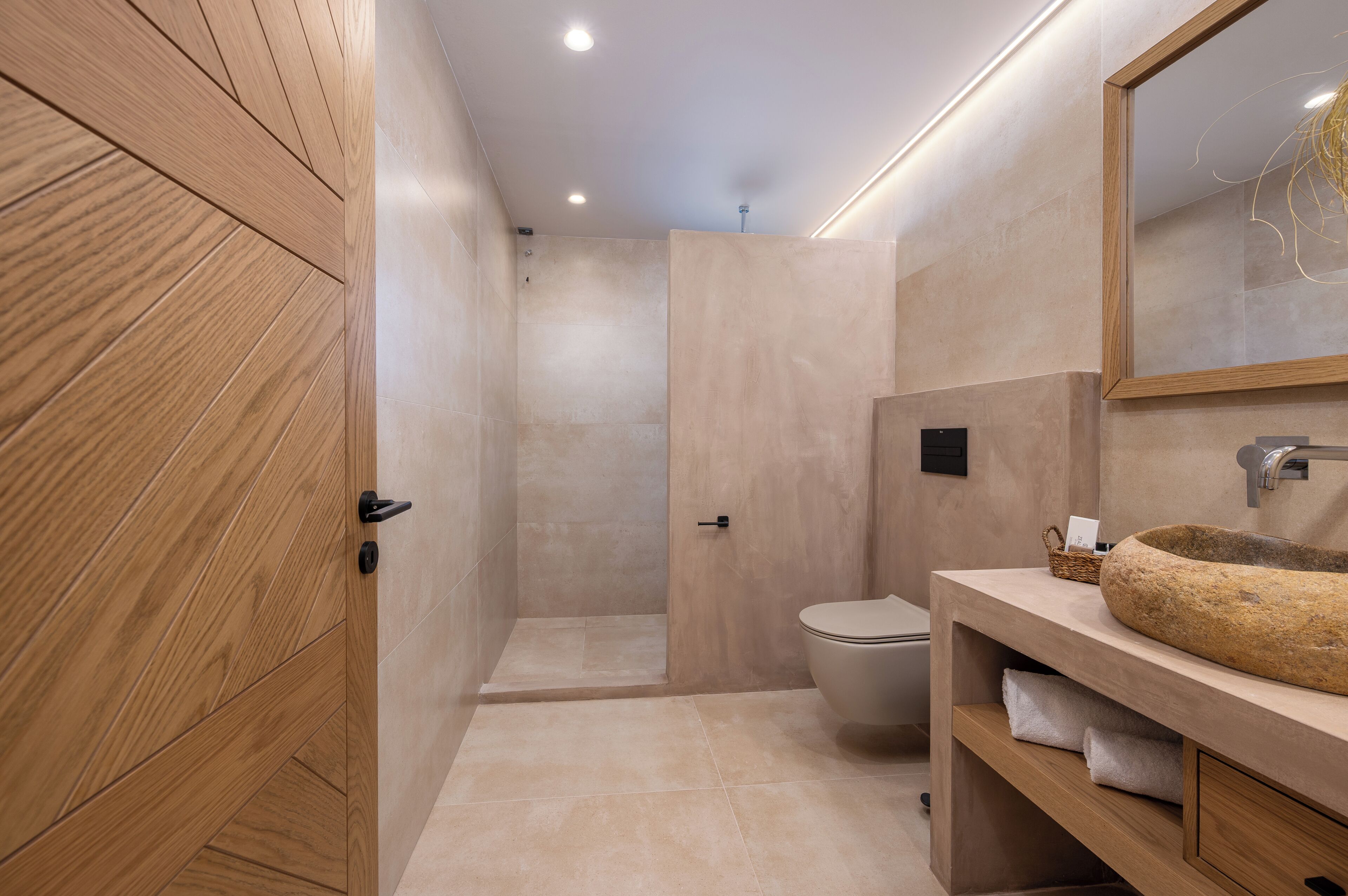 A modern bathroom with a wooden cabinet, a stone sink, and a shower area.