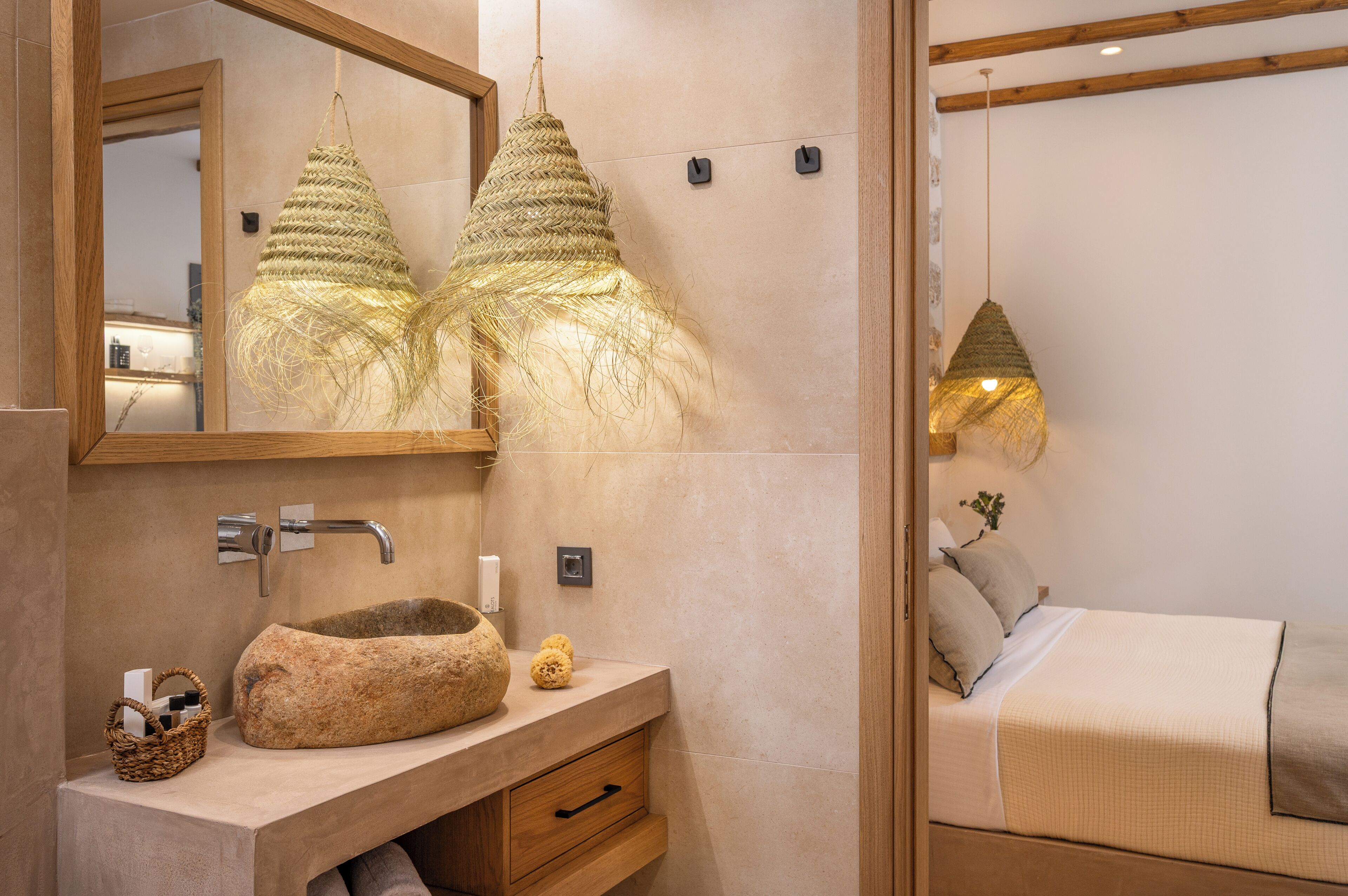 A modern bathroom with a stone sink, a wooden vanity, and a large mirror.