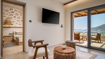 Habitació moderna amb televisió de pantalla plana, mobles de vimetla i vista al mar.