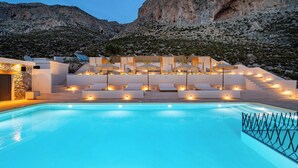 Ein Poolbereich mit Liegestühlen und einer Treppe, die zu einer Terrasse führt.