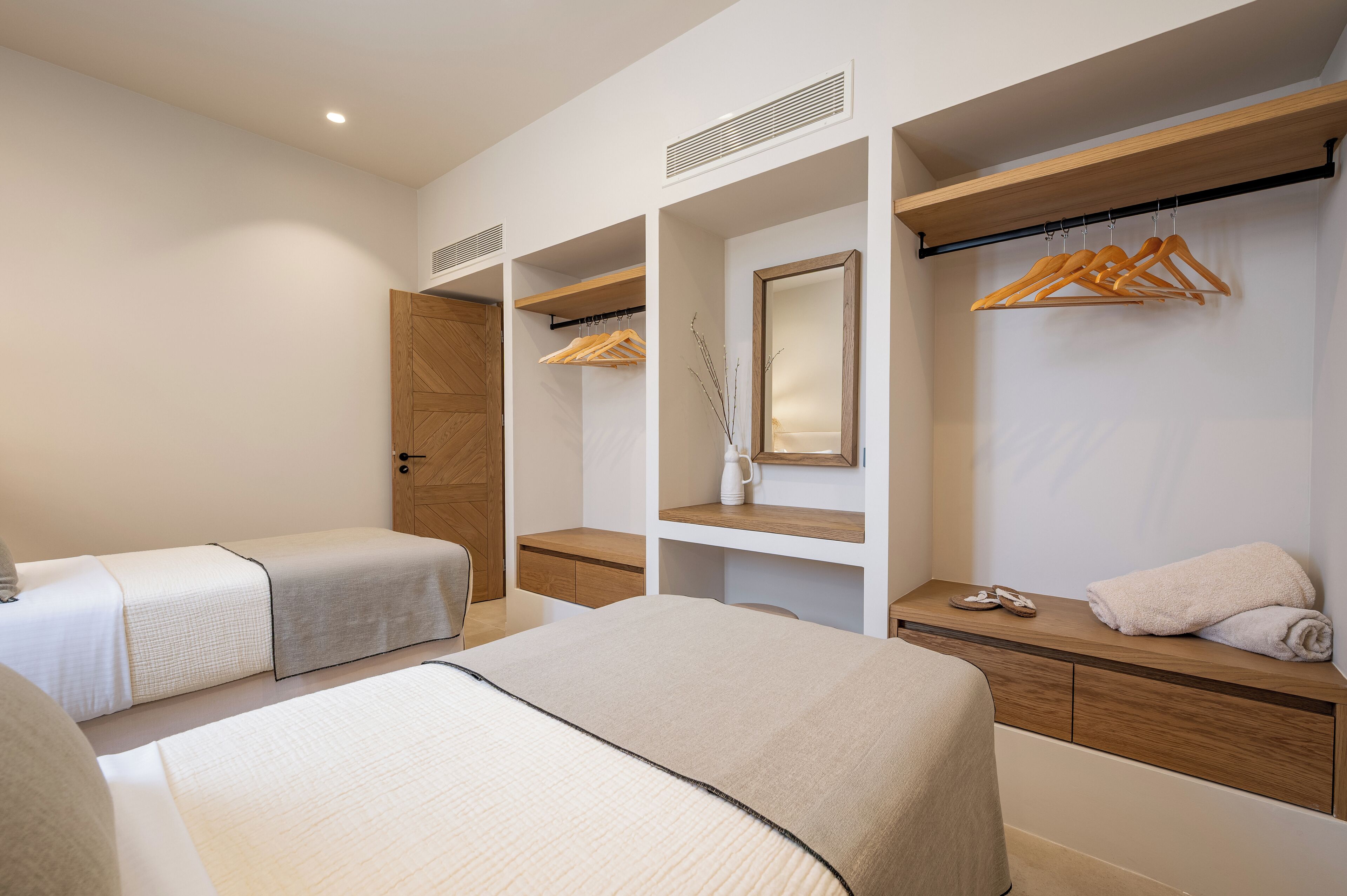 Una habitación de hotel con una cama grande, un escritorio, un armario y un espejo.