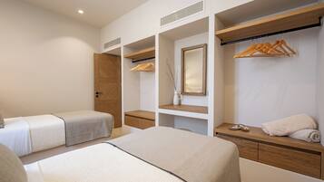 Una habitación de hotel con una cama grande, un escritorio, un armario y un espejo.