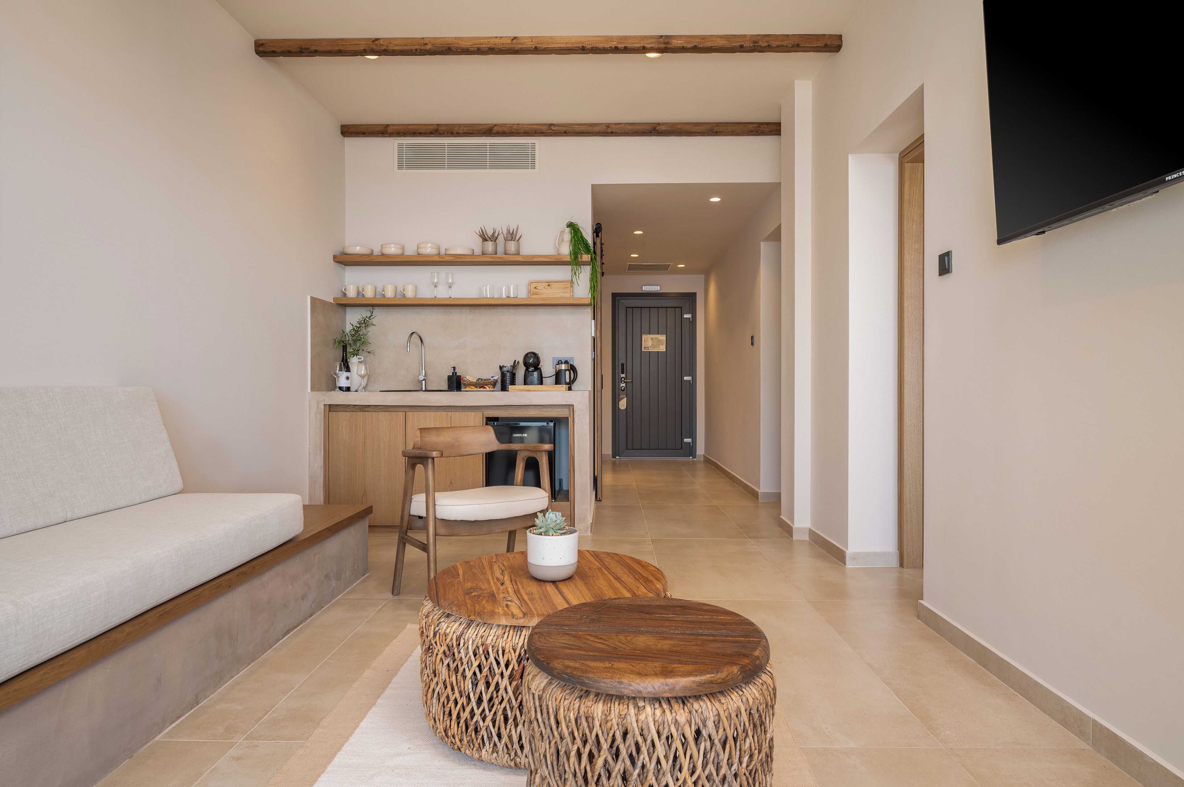 Eine moderne Küche mit Holzböden, ein Essbereich mit einem runden Holztisch und eine Sitzecke mit einer Couch.