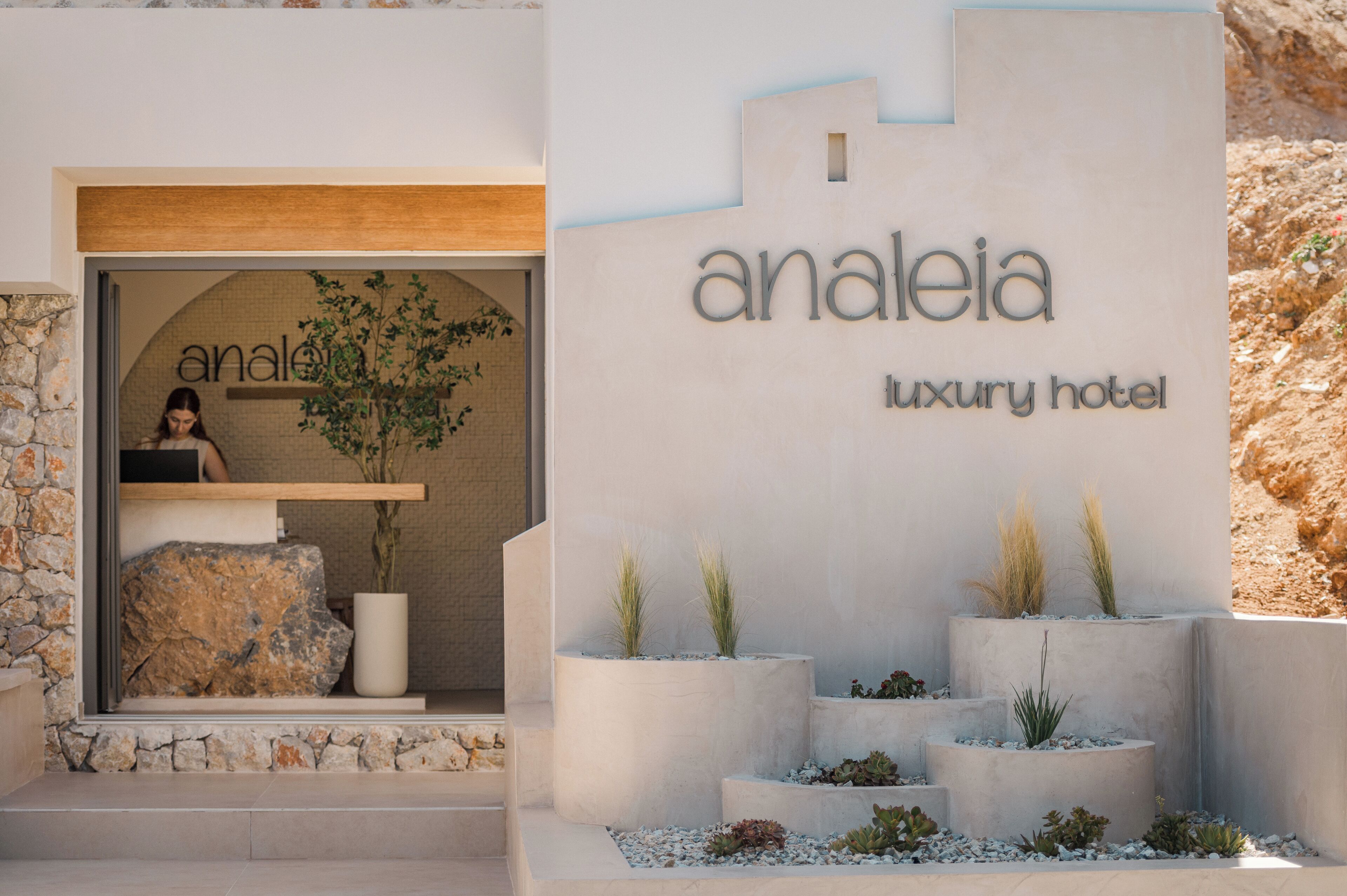 A luxury hotel entrance with a sign reading 'analeia luxury hotel' and a stone facade.