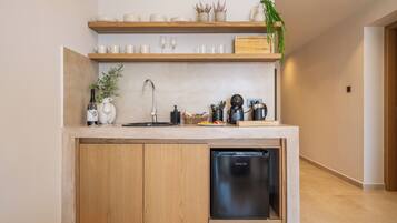Una cocina compacta con lavavajillas, armarios de madera y una encimera con diversos utensilios de cocina.